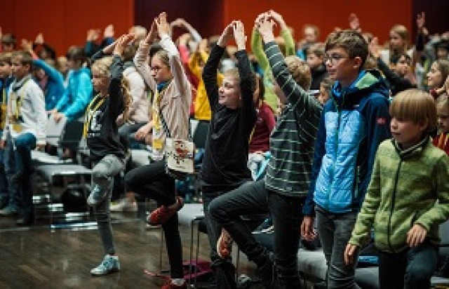 Kinder-Universität: Viele Kinder machen zusammen eine Yoga-Übung