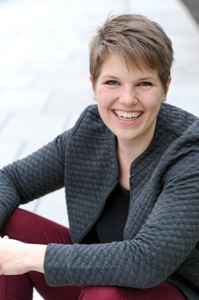 Portraitfoto von Dr. Solvejg Nitzke vor hellem Hintergrund. Sie lächelt zugewandt in die Kamera. 