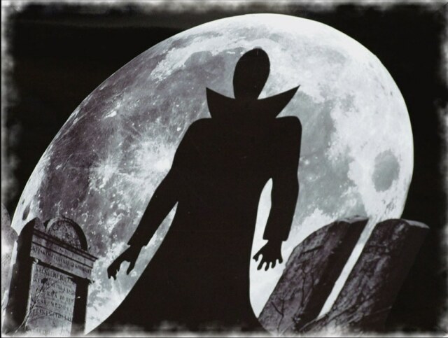 Ein schwarz-graues Bild eines Friedhofes. In der Mitte die Silhouette einer Gestalt im Umhang, die an Dracula erinnert. Der Mond nimmt den Hintergrund des Bildes ein.