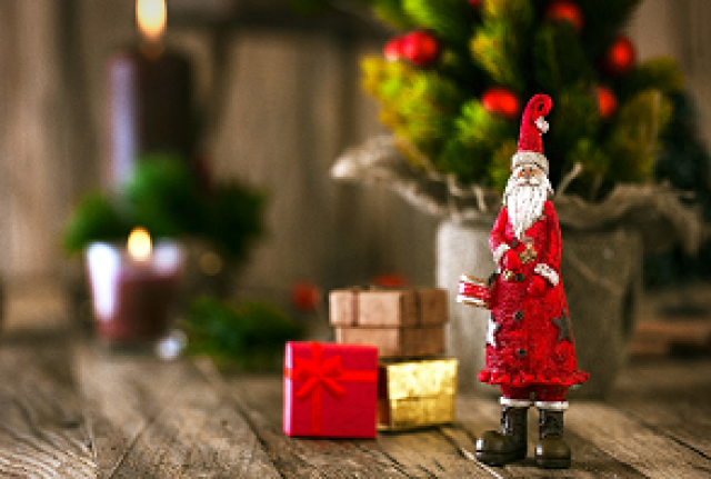 Geschenke und Weihnachtsmannfigur auf Holztisch
