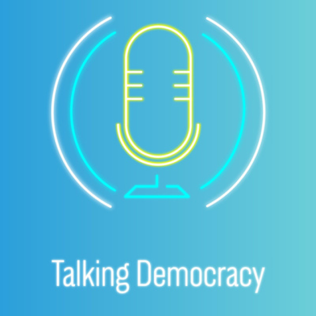 Auf blauem Hintergrund ist in Gelb das Symbol eines Mikrofons zu sehen, darunter der Titel des Podcasts 'Talking Democracy'.