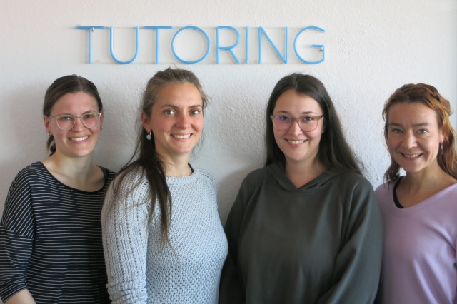 Foto vom Team TUTORING vor dem TUTORING Logo (v.l.n.r. Michelle Eichler, Melanie Ludwig, Lydia Kilz, Mirjam Koerber