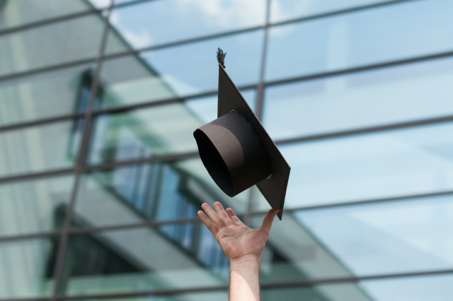 Picture of a hand, throwing a doctoral hat