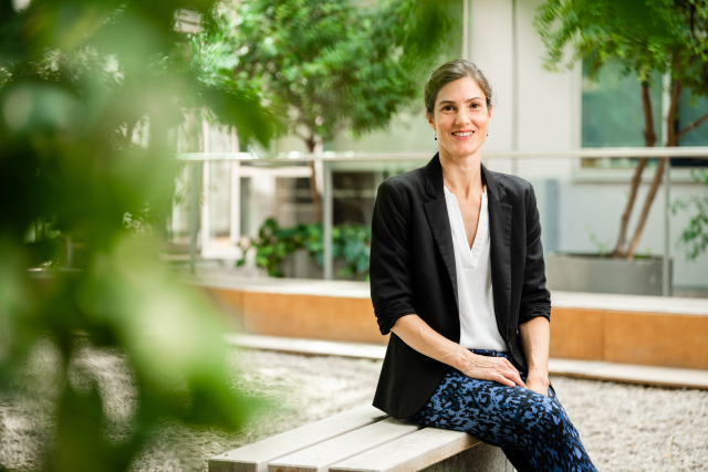 Photo Prof. Elena Hassinger, sitting on a bench