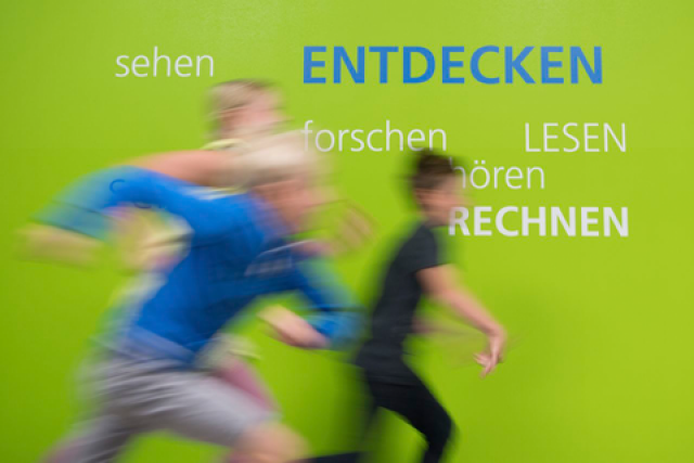 grüner Hintergrund, drei verschwommene Personen rennen von links nach rechts, darüber steht Entdecken in blauen Großbuchstaben und weitere Wörter in grauer Schrift