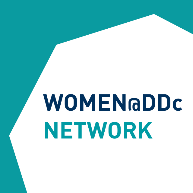 Visual with Women@DDc Network inscription in a cut octagon on a blue and green background.  