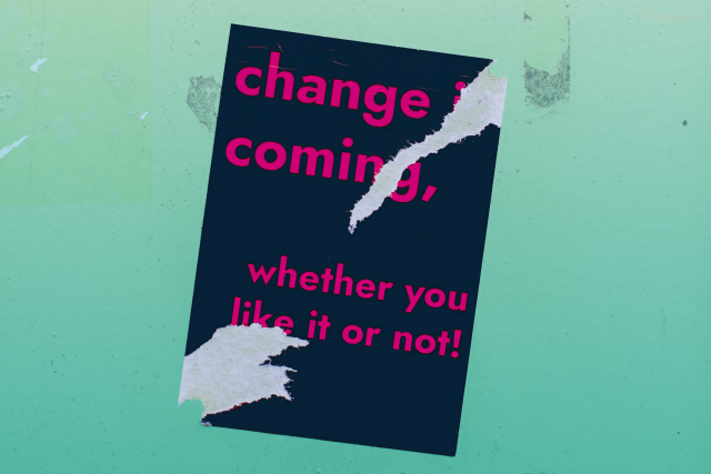  Angeknibbelter Sticker auf einer Wand, Text: Change is coming, whether you like it or not.