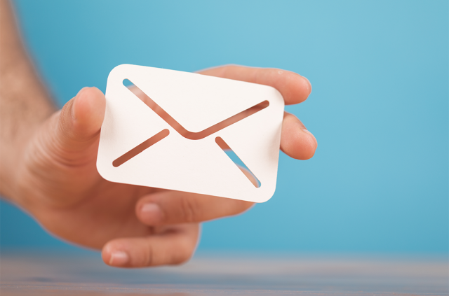 Eine zwischen den Fingern gehaltene E-Mail symbolisiert den Erhalt des Newsletters.