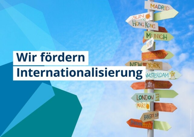 Das Bild trägt den Aufdruck „Wir fördern Internationalisierung“ und zeigt einen bunten Wegweiser mit den Namen von Städten weltweit vor einem Hintergrund aus verschiedenen Blautönen. 
