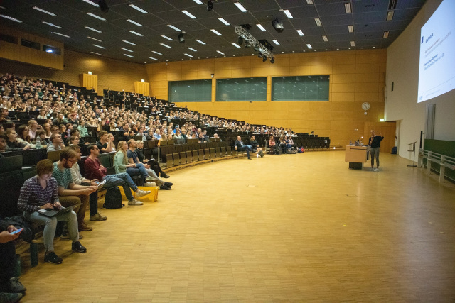 Professorin hält Vortrag in einem Hörsaal voller Studierender.