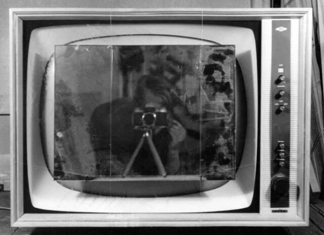 Das Foto zeigt ein altes Fernsehgerät, das Foto ist schwarz-weiß.