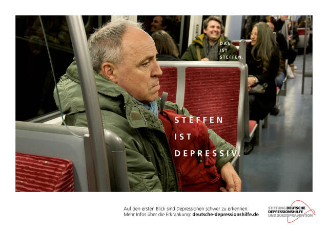 Das Werbeplakat der Stiftung Depressionshilfe. Es zeigt einen Mann, der im Bus oder in der Straßenbahn sitzt und traurig schaut. Im Hintergrund sitzen Personen und unterhalten sich.