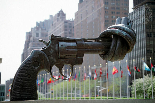 Larger-than-life sculpture of a revolver with a knotted barrel