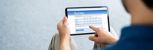 A person is holding a tablet. It shows a rough outline of a survey.
