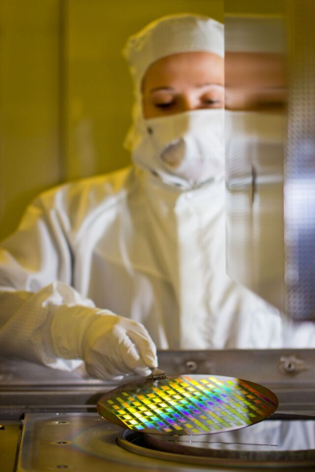 Forscherin mit einer Platte von Mikrochips.