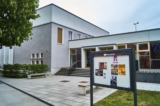 Kino im Kasten from the outside. A display case with movie posters can be seen in the foreground.