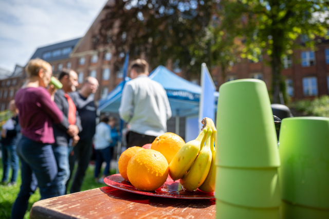 Cups and jugs in the foreground, people talking in the background