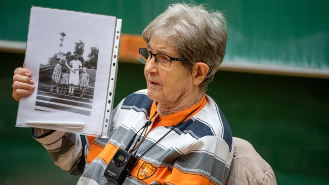Picture of Renate Aris holding a black/white-picture in her hand
