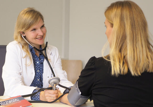 A Medical Officer measuring blood pressure.