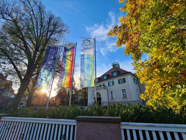 There are 3 flagpoles in front of the TUD Rectorate. The flag is flown from left to right with the TUD flag, the Progressive Pride Flag and the DresdenConcept flag.