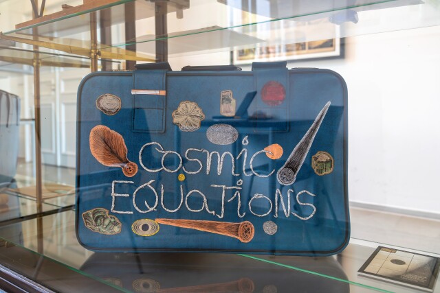 The photo shows a detail from Sophie Lindner's exhibition. A blue suitcase invites you to travel to distant worlds.