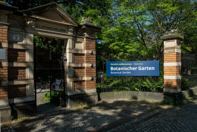Photo of the entrance area to the Botanic Garden, brick gate, sign with the inscription Botanic Garden