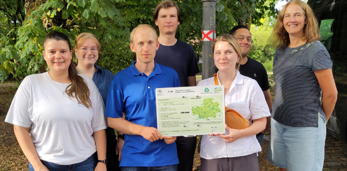 5 Mitarbeiterinnen und Mitarbeiter der JuBis, die draußen an einer Parkbank die 5 Faktoren für gelingende Resilienz nachstellen