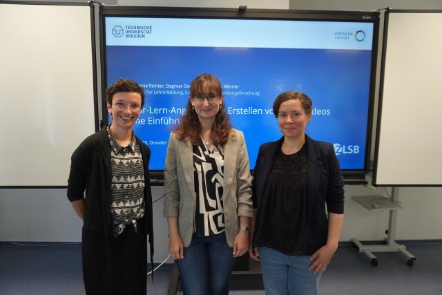 Drei Frauen in der Gruppe vor Startfolie einer Präsentation