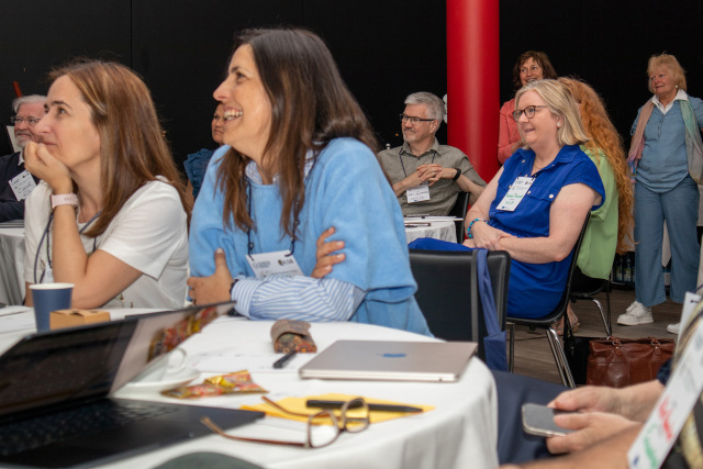 Mehrere Personen sitzen an einem Tisch und lachen zusammen