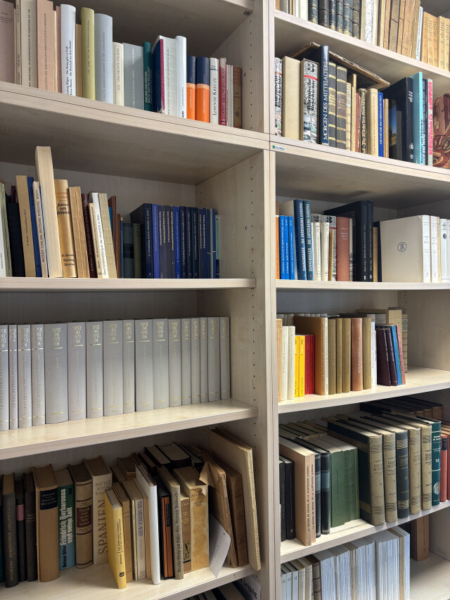 Photography of two shelves full of books.